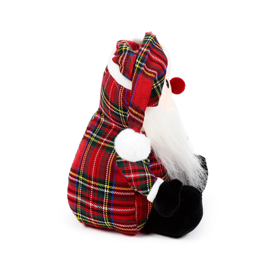 Angled view of a red Scottish tartan gonk door stop, featuring a white beard, red bobble nose, red tartan hat with white pom-pom and trim, and black feet.