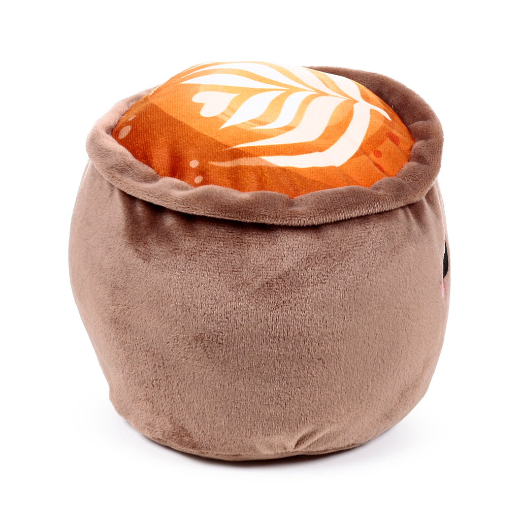 Angled view of a plush cappuccino cup door stop, with a brown fuzzy body and an orange top featuring white latte art patterns.