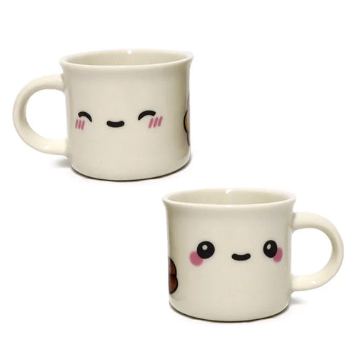 Angled view of two cream porcelain espresso cups, one with a smiling face and cheek blushes, the other with round eyes and pink cheeks.