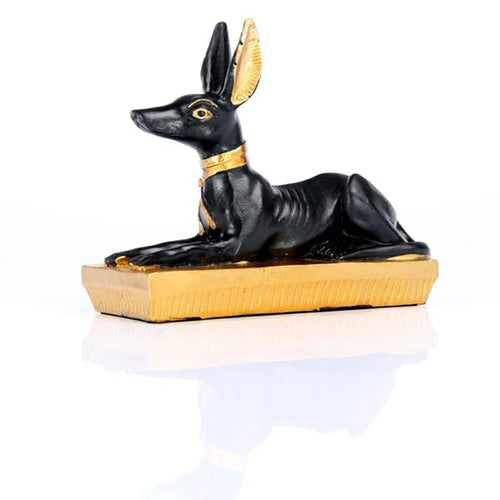 Side profile view of a gold and black Egyptian Anubis jackal figurine.