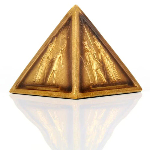 Angled view of a gold Egyptian pyramid ornament with detailed hieroglyphic figures.