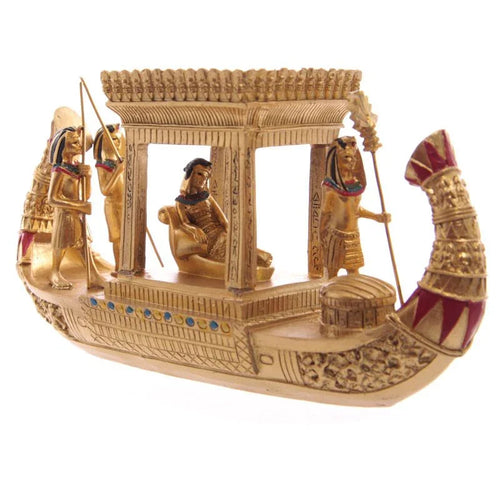 Angled view of a decorative gold Egyptian canopy boat figurine featuring a seated royal figure under a canopy, surrounded by standing attendants with staffs.