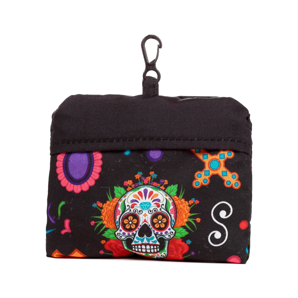 Front view of a black, folded shopping tote pouch with a vibrant Day of the Dead sugar skull design, colourful flowers, and a black carabiner clip.
