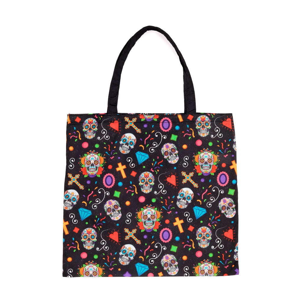 Front view of a black foldable shopping bag featuring a vibrant Day of the Dead design. The all-over pattern includes colourful sugar skulls, crosses, hearts, and diamond shapes, complemented by two black fabric handles.
