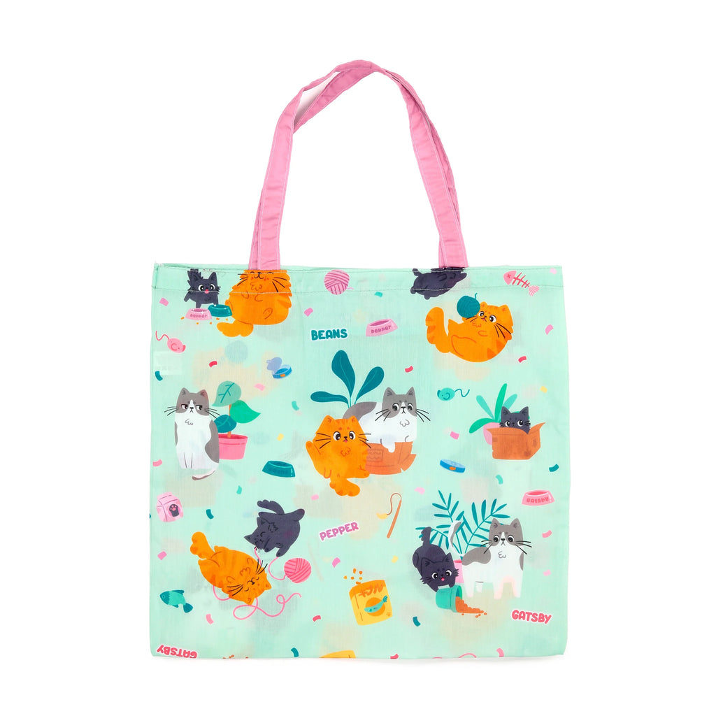 Front view of a mint green shopping tote bag with pink handles, featuring a playful pattern of various cartoon cats with yarn, potted plants, and food bowls.