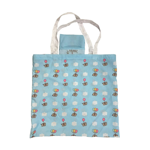 Front view of a light blue foldable shopping tote bag with white handles. The bag features a repeating pattern of Pusheen cats holding colourful balloons (pink, yellow, green) and white clouds. A small light blue storage pouch is visible at the top.