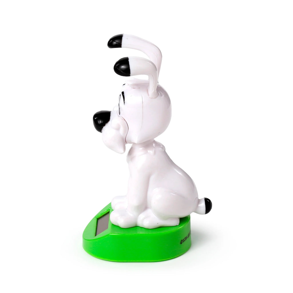 Side view of a white Asterix Idefix (Dogmatix) solar powered pal figurine with black ears and nose, sitting on a green base with a solar panel.