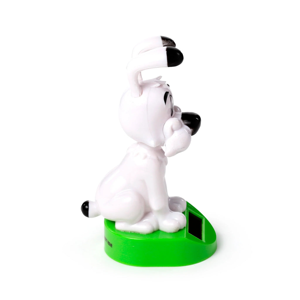 Side view of a white Idefix (Dogmatix) solar powered collectible dog figurine sitting on a bright green base with a black solar panel.