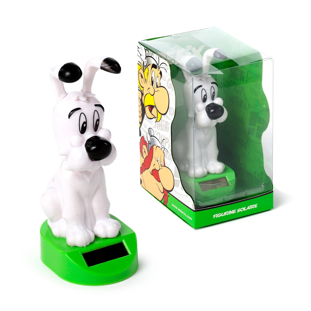 Angled view of a white Asterix Idefix (Dogmatix) solar powered pal figurine on a green base with a solar panel, positioned next to its clear plastic retail packaging adorned with Asterix characters.