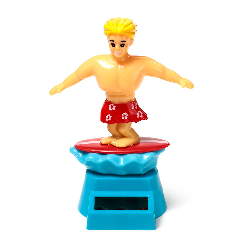 Front view of a Solar Pal Surger Dude figurine with blonde hair, red floral shorts, standing on a red surfboard. The figure is on a blue wave base and a light blue stand with a solar panel.