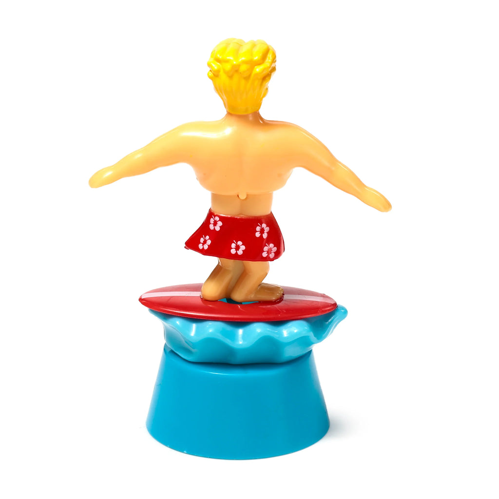 Solar Pal Surger Dude figurine, shown from behind, revealing blonde hair, red shorts with white floral patterns, standing on a red surfboard atop a wavy light blue and conical deeper blue base.