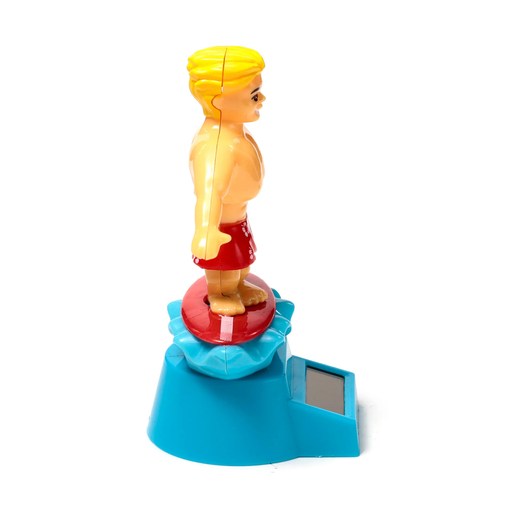 Side view of a blonde Surger Dude Solar Pal, a tan figure wearing red floral swimming shorts, standing on a red disc atop a turquoise base with a solar panel.