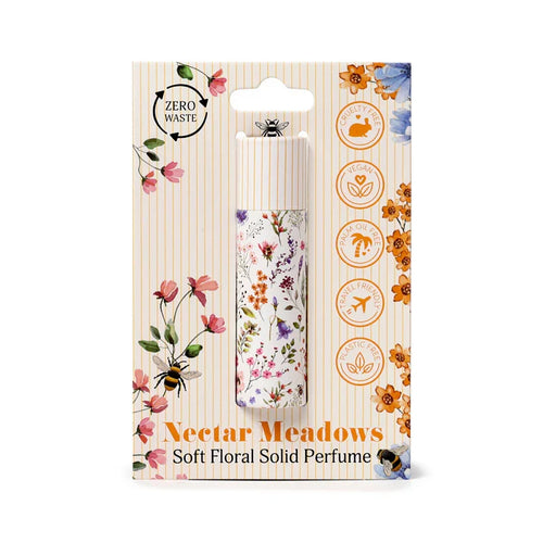 Front view of a Nectar Meadows Solid Perfumed Stick Balm in retail packaging. The white tube, adorned with a multi-colored floral pattern, is displayed within a striped cardboard package featuring colorful flower and bee illustrations. Visible text on the packaging highlights 'Zero Waste', 'Cruelty Free', 'Vegan', 'Palm Oil Free', 'Travel Friendly', and 'Plastic Free' attributes.