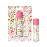 Front view of a solid perfumed stick with a pink cap and a pink botanical floral design, displayed in its matching zero-waste packaging, alongside an identical stick standing freely on a white background. The packaging highlights features like cruelty-free, vegan, palm oil free, travel friendly, and plastic free.