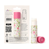 Studio shot of two solid perfumed stick balms, one in its white packaging with a pink and green botanical floral print, and another standing upright with its pink cap removed and the white balm extended.