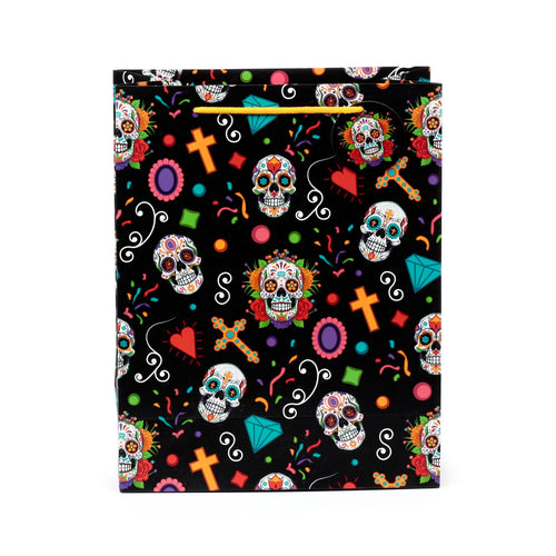 Front view of a large gift bag with a black background and colourful Day of the Dead pattern, featuring sugar skulls, crosses, hearts, and diamonds, with yellow braided cord handles.