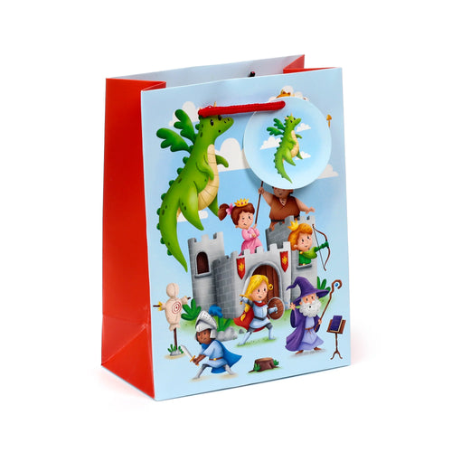 Front view of a medium gift bag, featuring a colourful knights and dragons illustration. The light blue front panel depicts a large green dragon, a castle, a princess, knights, an archer, and a wizard. The bag has red side panels, a red base, and red braided rope handles, with a circular tag showing a small green dragon.
