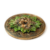 Angled product shot of a round Greenman ashcatcher incense burner, featuring a bronze finish with green leaves forming the face and intricate Celtic knot patterns.