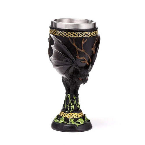 Front view of a black decorative goblet featuring a 3D bat figure with red eyes, gold Celtic knot designs, green vine accents, and a stainless steel interior.