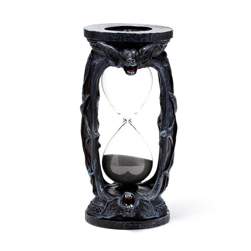 Front view of a dark sculpted hourglass ornament with bat wing details and bat faces with red accents, containing black sand.