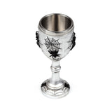 Angled view of a silver-coloured decorative goblet with black spider web designs and raised black spiders, showing its metallic interior.