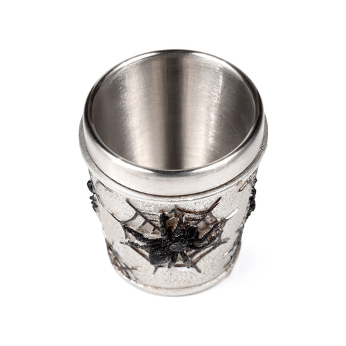 Decorative shot glass with a silver-grey metallic exterior featuring raised black spider and spider web details, viewed from above, showcasing its brushed metallic interior.