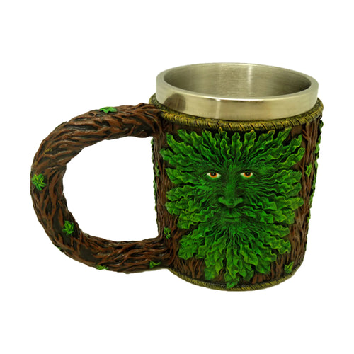 Angled view of a decorative Treeman tankard, depicting a face made of green leaves on a brown tree bark textured body. It features a tree branch-shaped handle and a silver-coloured rim.
