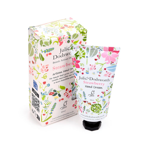 Angled view of a 50ml moisturising hand cream tube with a black cap and its matching packaging box, both displaying a vibrant pink botanical floral pattern on a white background.