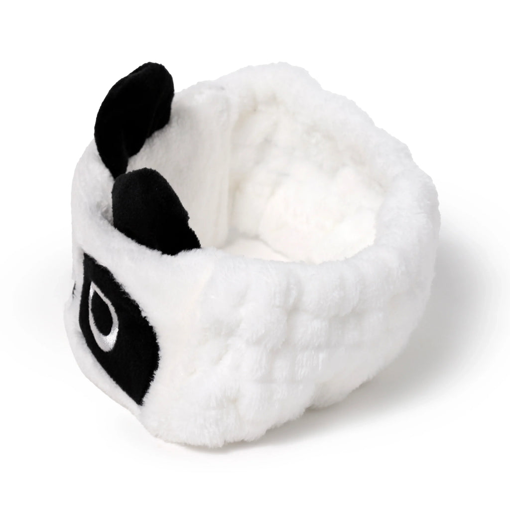 Plush panda headband, white with black ears and embroidered eye, 3/4 view product shot.