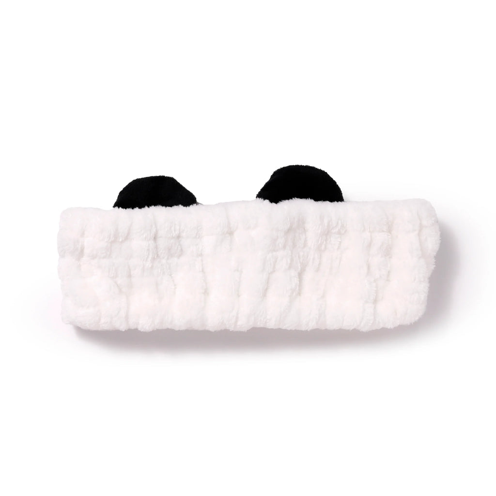 Front view of a white plush headband with black panda ears.