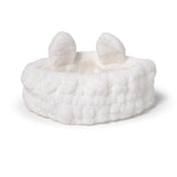 Front view of a white plush headband with rabbit ears.