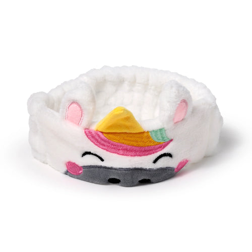 Front view of a white plush unicorn headband featuring embroidered yellow horn, pink and yellow mane, black closed eyes, pink cheeks, and a grey snout.