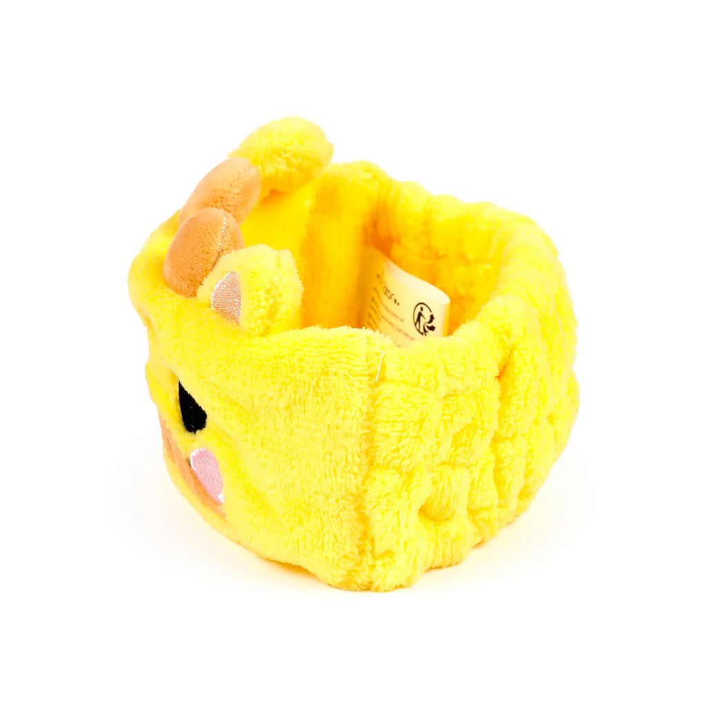 Angled view of a yellow plush giraffe headband, featuring brown ossicones, ears, a pink muzzle, and black eyes.