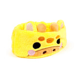 Yellow plush giraffe beauty headband, front view, with embroidered eyes, snout, pink cheeks, soft ears, and horns.