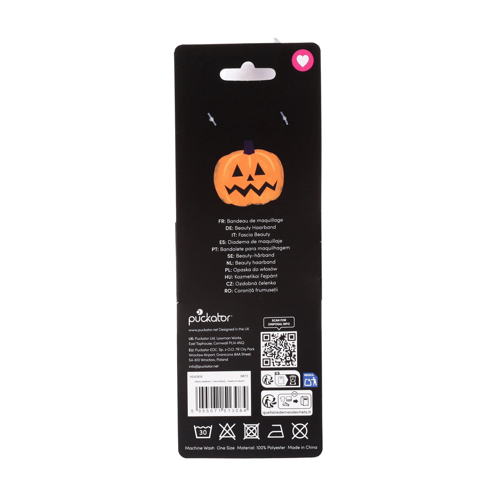 Reverse view of black packaging for a plush beauty headband, featuring an orange jack-o'-lantern illustration, a hanging tab, barcode, and care instructions.