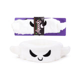 Front view of a white plush ghost beauty headband with black embroidered face, displayed with its purple 'Spooky!' retail packaging.