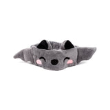 Angled front view of a grey plush headband featuring a bat design with black pointed ears, wing-like sides, an embroidered black nose, smiling eyes, and pink cheeks.