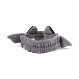 Angled view of a grey plush beauty headband, featuring bat ears with black inner details and grey bat wings.