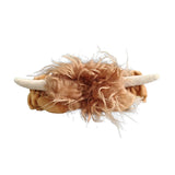 Front view of a plush Highland Coo headband, featuring shaggy light brown fur and cream-colored horns.