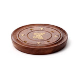 Angled view of a round dark brown Sheesham wood ashcatcher, featuring a central brass butterfly inlay, small brass star details, and holes for incense sticks.