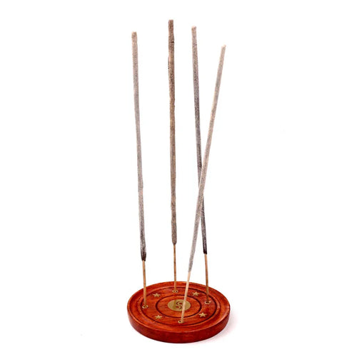 Front view of a round decorative reddish-brown wooden incense holder ashcatcher, featuring a golden S-shaped central symbol, star embellishments, and holding five unlit incense sticks.