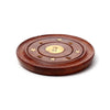 Angled view of a round, dark brown Sheesham wood incense holder, designed as an ashcatcher. It features a central brass Yin Yang inlay, four brass star inlays, and four brass holes for incense sticks within a circular groove.