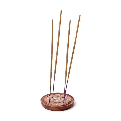 Angled view of a round sheesham wood ashcatcher incense holder, featuring a light-coloured crescent moon and star inlay, holding four brown and purple incense sticks.