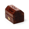 Angled view of a dark brown Sheesham wood mini incense cone burner box, featuring a perforated roof with leaf-shaped cut-outs and a brass-coloured elephant inlay on its front.