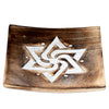 Angled view of a square mango wood incense ashcatcher, featuring a white carved geometric star and spiral design on its dark brown surface, with two brass-coloured incense stick holes.