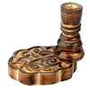 Angled view of a dark mango wood backflow incense burner, featuring a base with intricate carved swirling patterns and a golden-coloured cone holder.