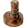 Angled view of a dark brown mango wood backflow incense burner, featuring carved floral garden patterns on its base and a golden top insert.