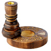 Angled view of a dark brown mango wood backflow incense burner. The central pillar features a golden-coloured cone holder, and its circular base displays intricate floral carvings surrounding a well for smoke, with a decorative golden bird inlay.