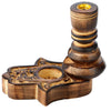 Angled view of a dark brown carved wooden Hamsa hand backflow incense burner, featuring intricate floral patterns, a circular incense cone well, and a tall pillar with a golden metallic holder.