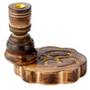 Angled view of a dark wooden backflow incense burner, featuring a carved Om symbol on its scalloped base and a golden incense cone holder at the top.